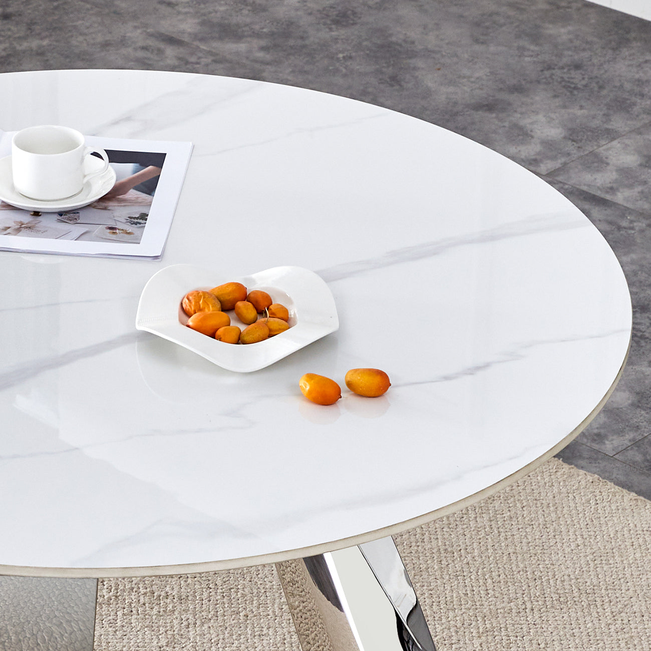 White marble top dining table with chrome base and a white teacup