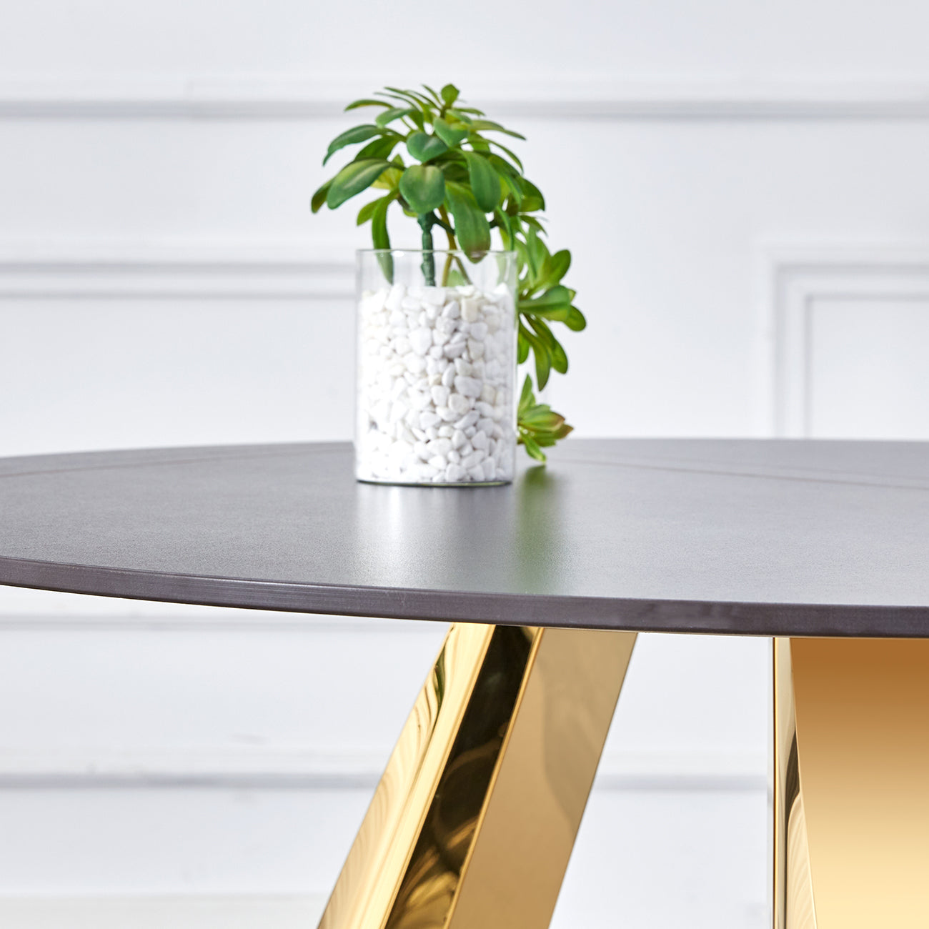 Round matte black dining table with polished gold geometric base