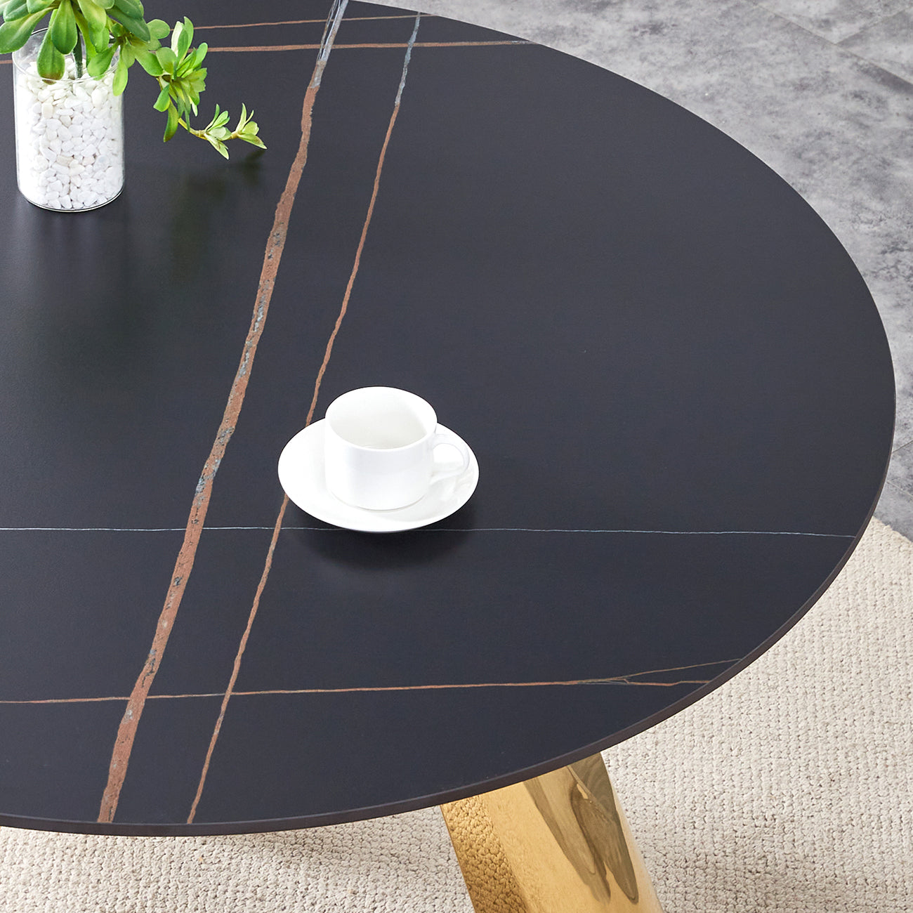 Black marble dining table with gold veining and a single white teacup