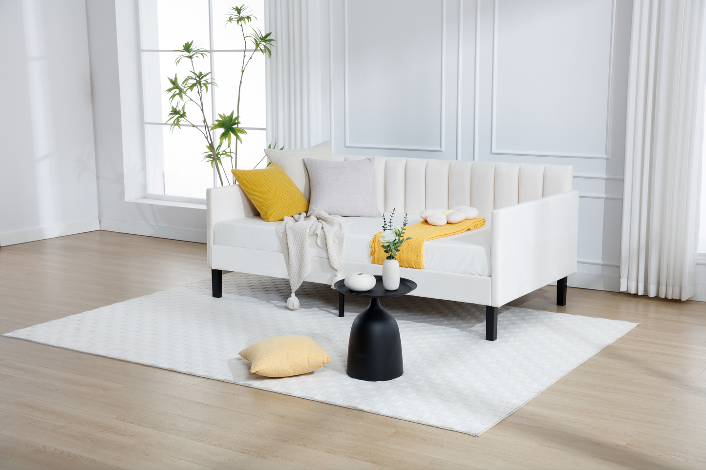 White tufted sofa with yellow and beige pillows and a white throw blanket
