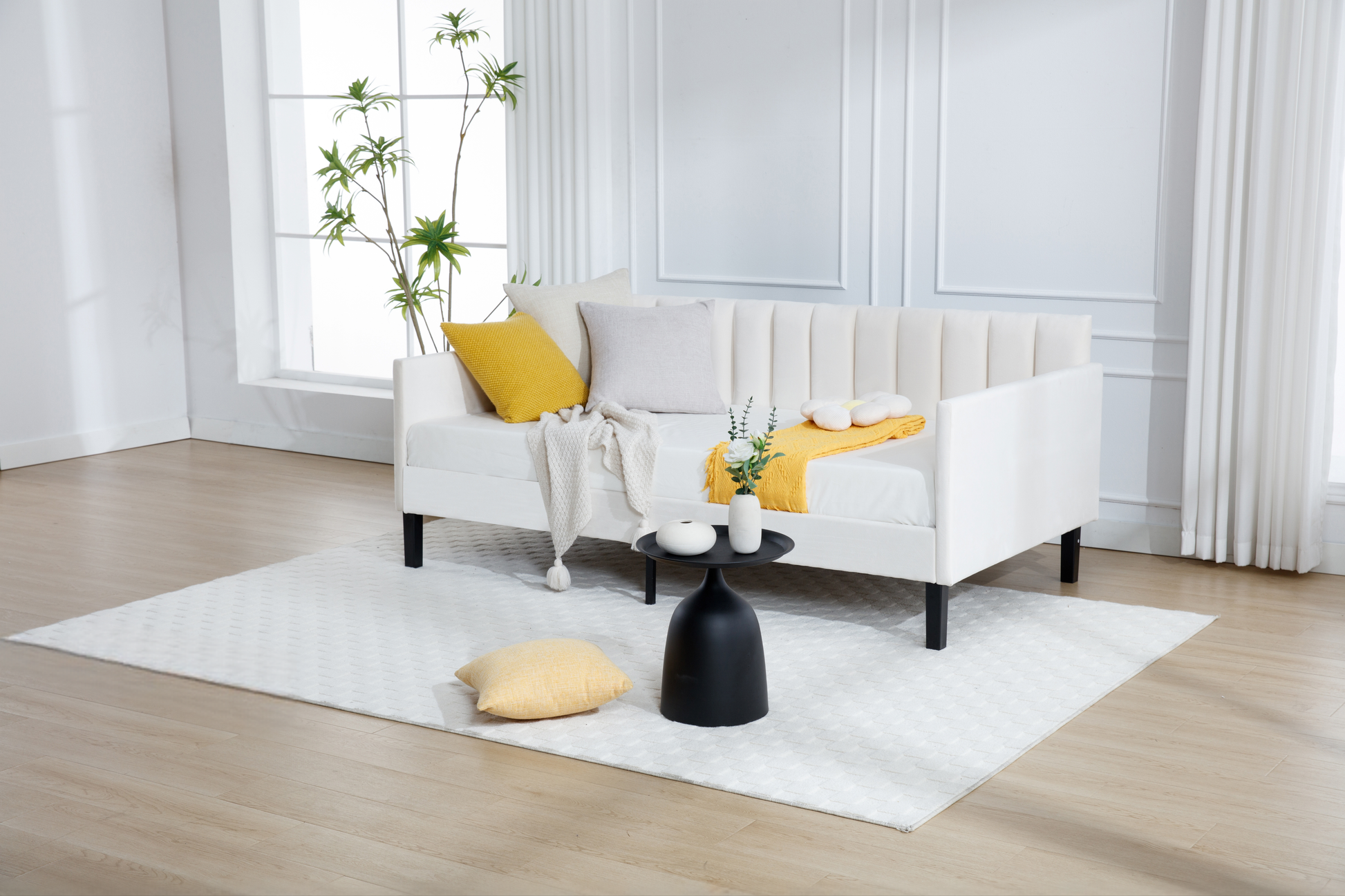 White tufted sofa with yellow and beige pillows and a white throw blanket