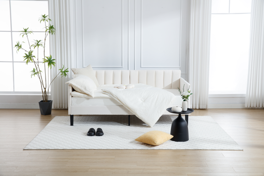 Elegant white tufted sofa with plush bedding and accent pillows