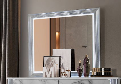 Illuminated vanity mirror with ornate silver frame reflecting a modern interior