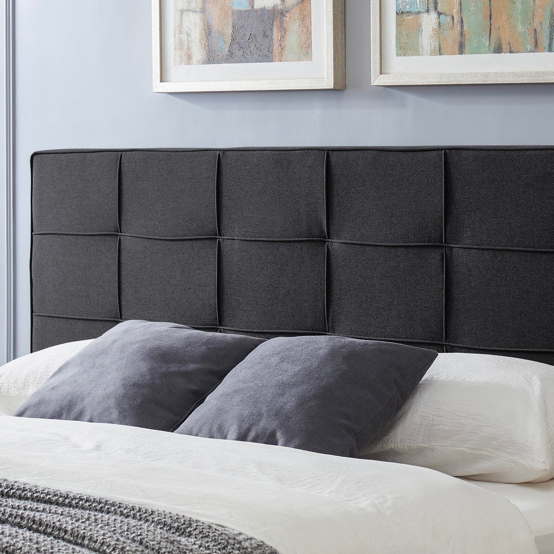 Dark charcoal fabric headboard with a modern tufted panel design