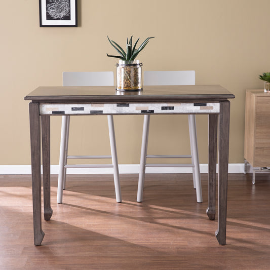 Dark wood dining table with mosaic inlay and curved legs