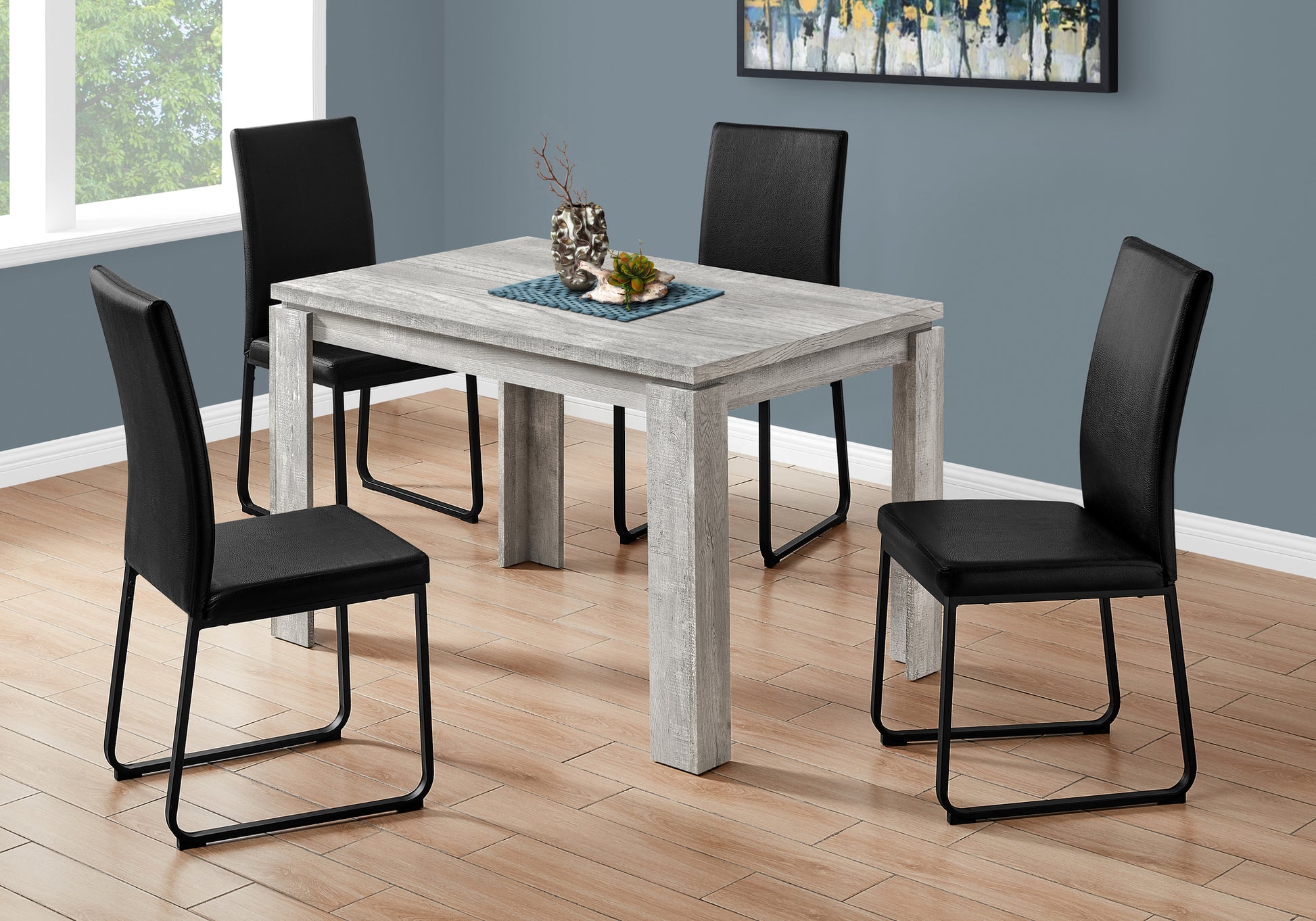 Rustic grey wood dining table with four black faux leather chairs