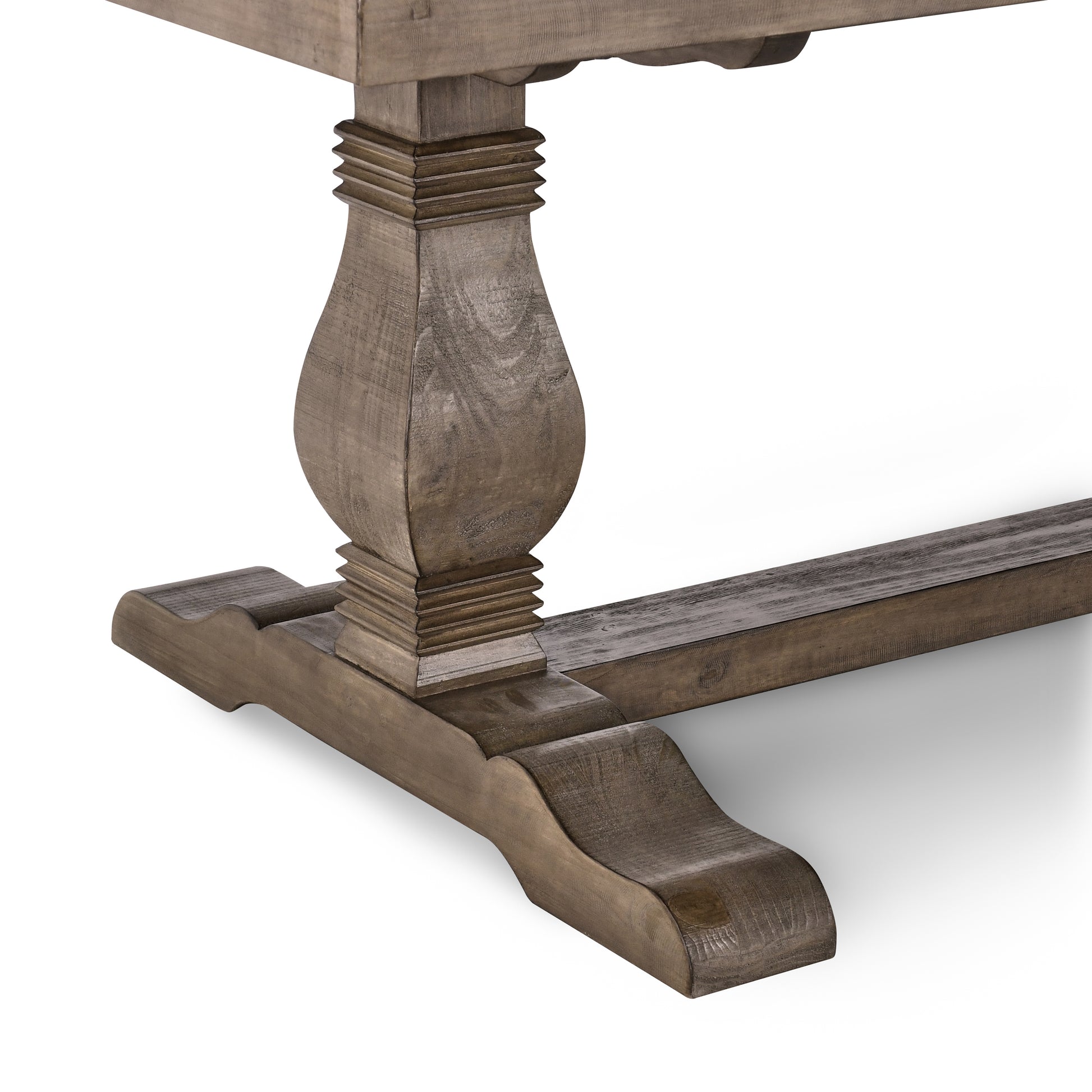 A closeup of a rustic reclaimed wood dining table base with carved details