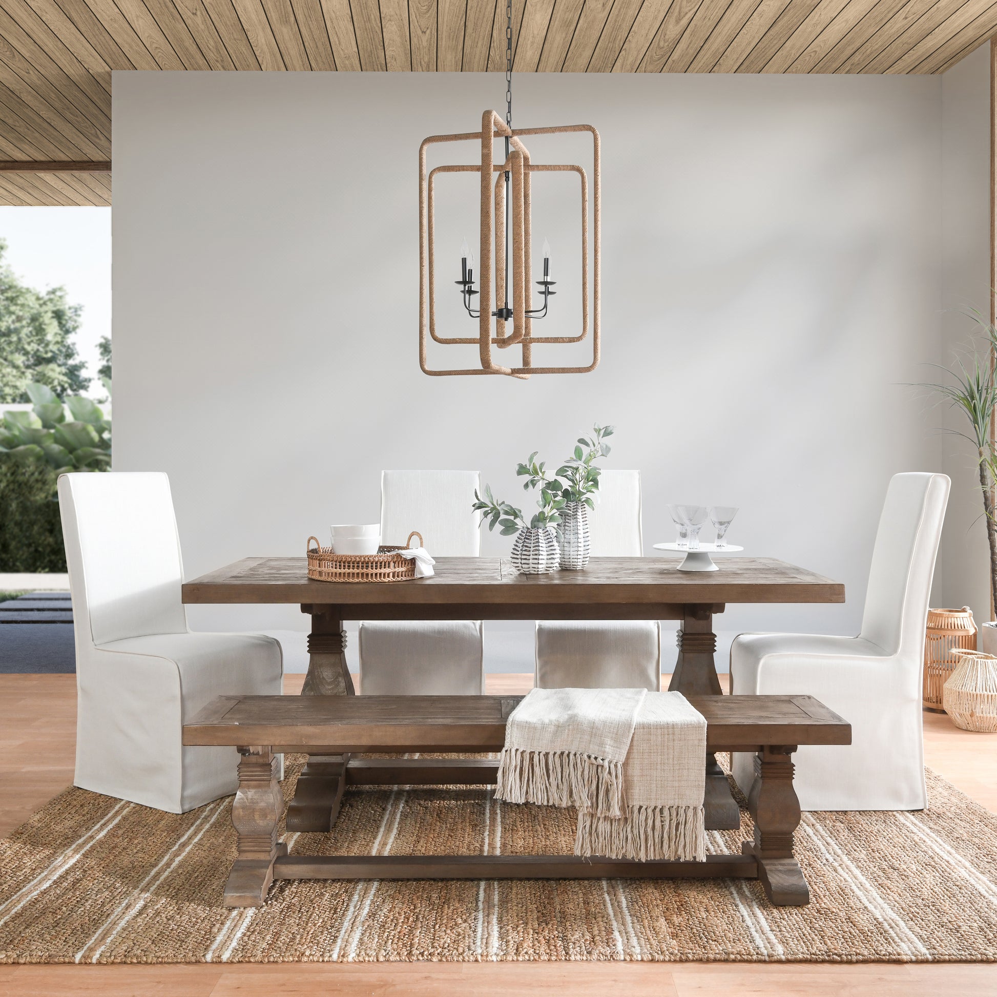 Rustic wooden dining table with white slipcover chairs and bench
