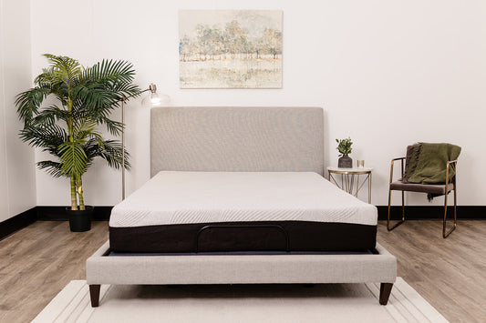 Adjustable bed frame with white striped mattress and grey headboard