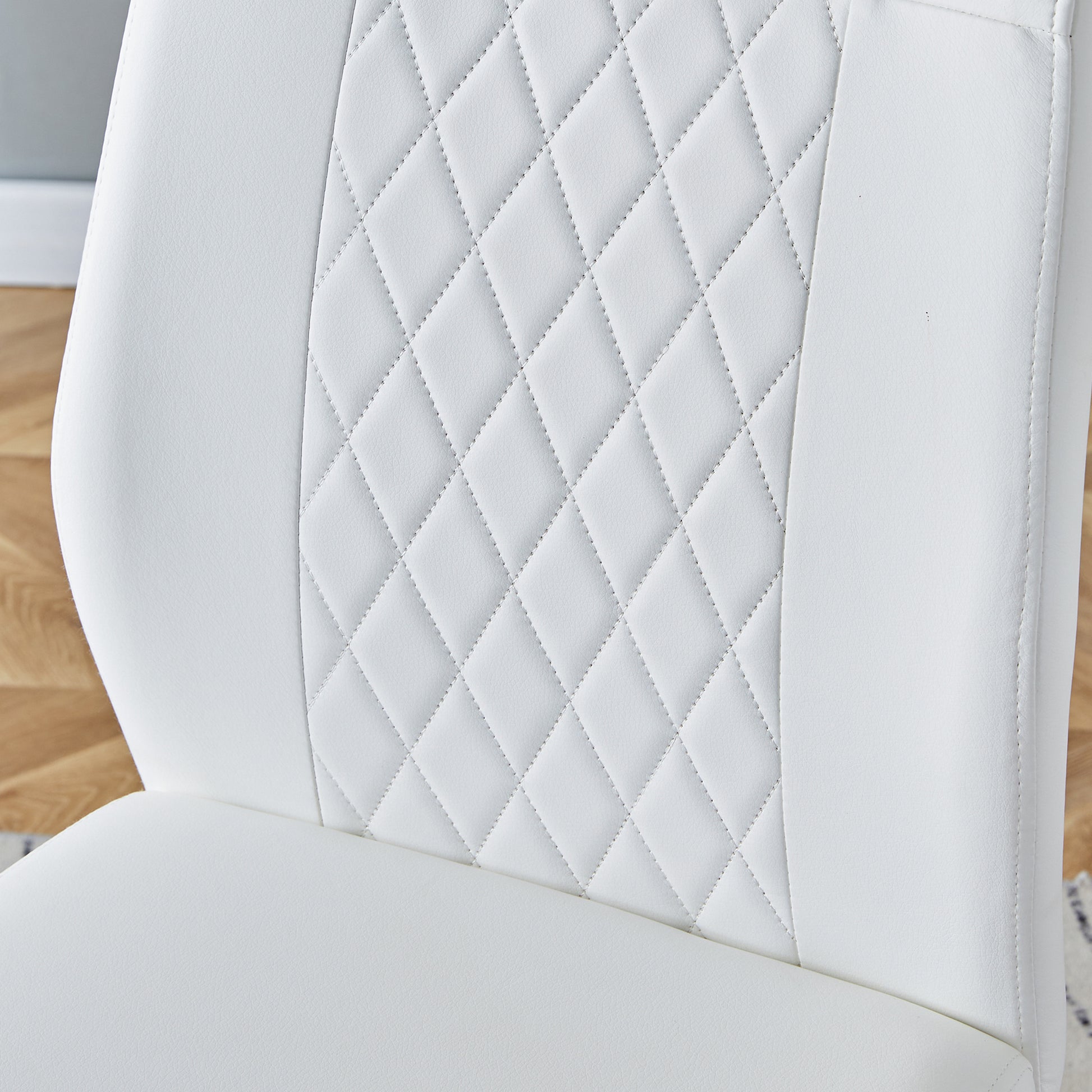 Closeup of white faux leather chair seat with diamond quilting