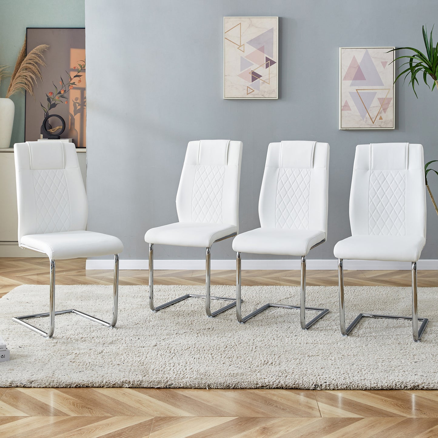 White faux leather dining chairs with diamond tufting and chrome sled base
