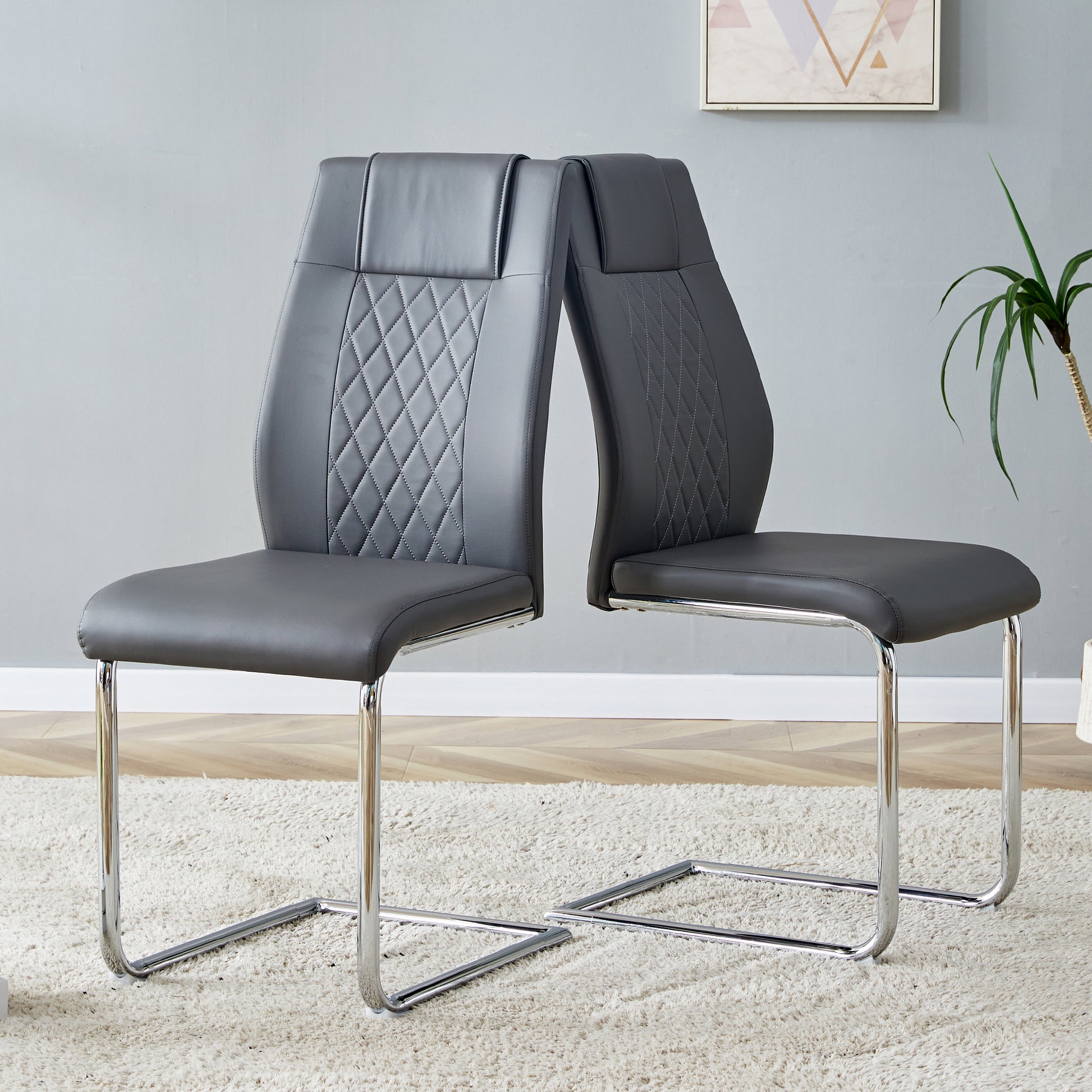 Gray faux leather dining chair with diamond stitching and chrome sled base