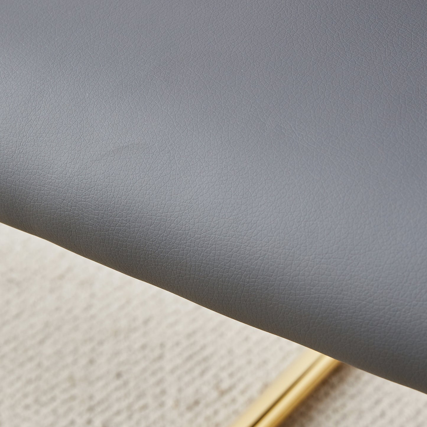 Closeup of textured grey faux leather upholstery on a modern chair
