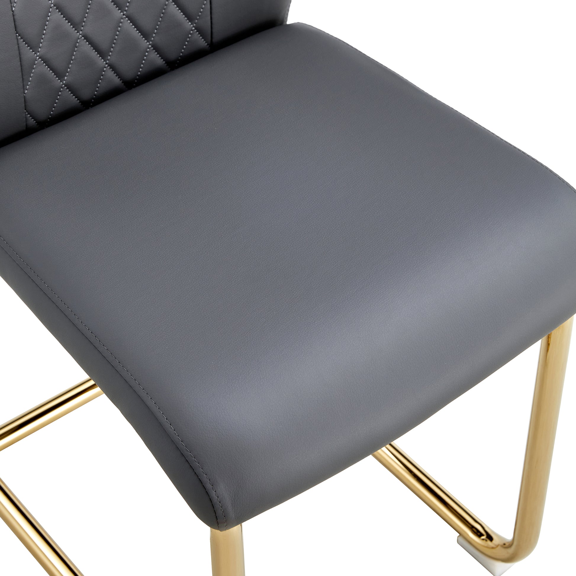 Closeup of a gray faux leather bar stool seat with diamond stitching and gold legs