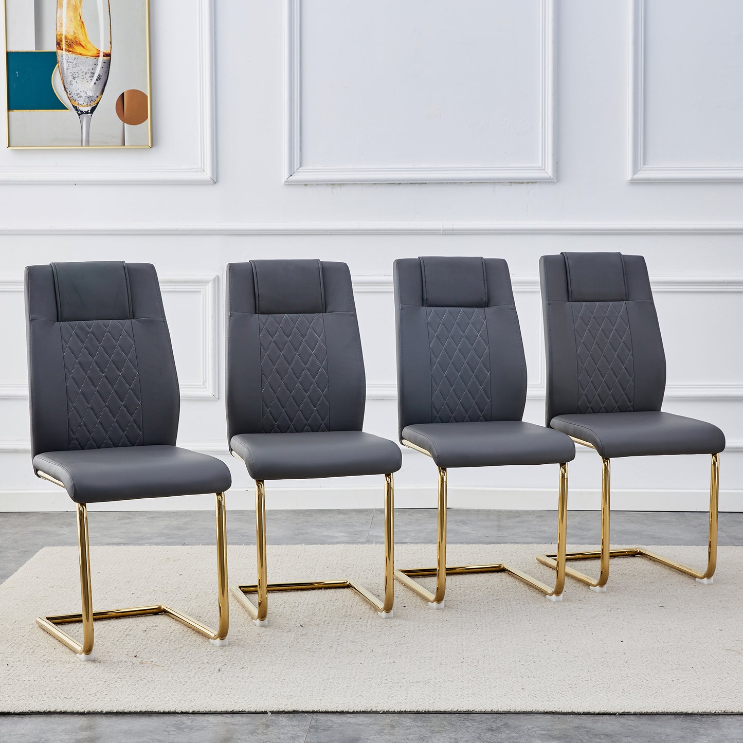 Four grey faux leather dining chairs with diamond tufting and gold sled legs