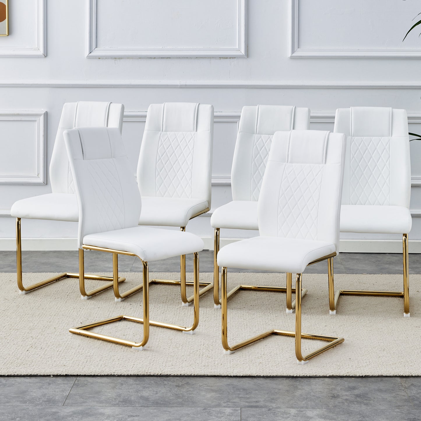 White leather dining chairs with diamond tufting and gold sled base