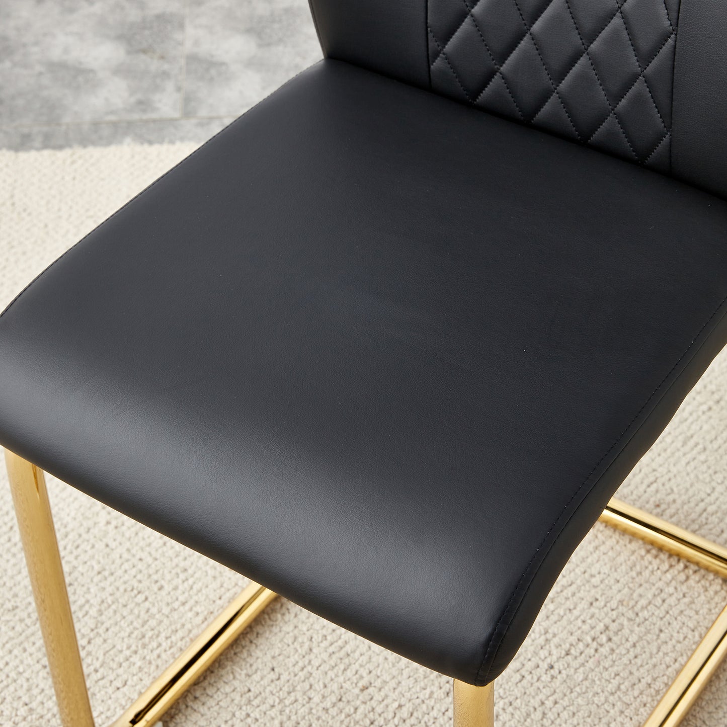 Black faux leather bar stool seat with diamond stitching and gold legs