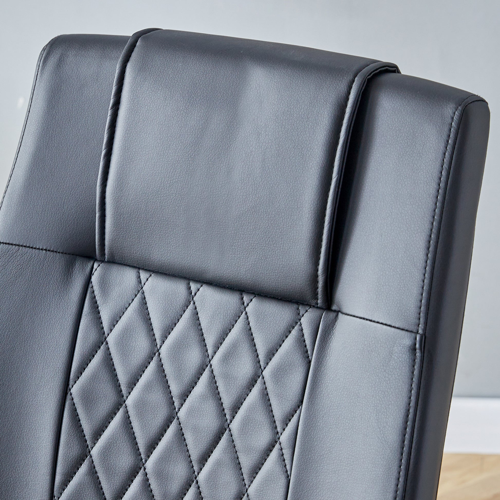 Black faux leather office chair headrest with quilted diamond pattern