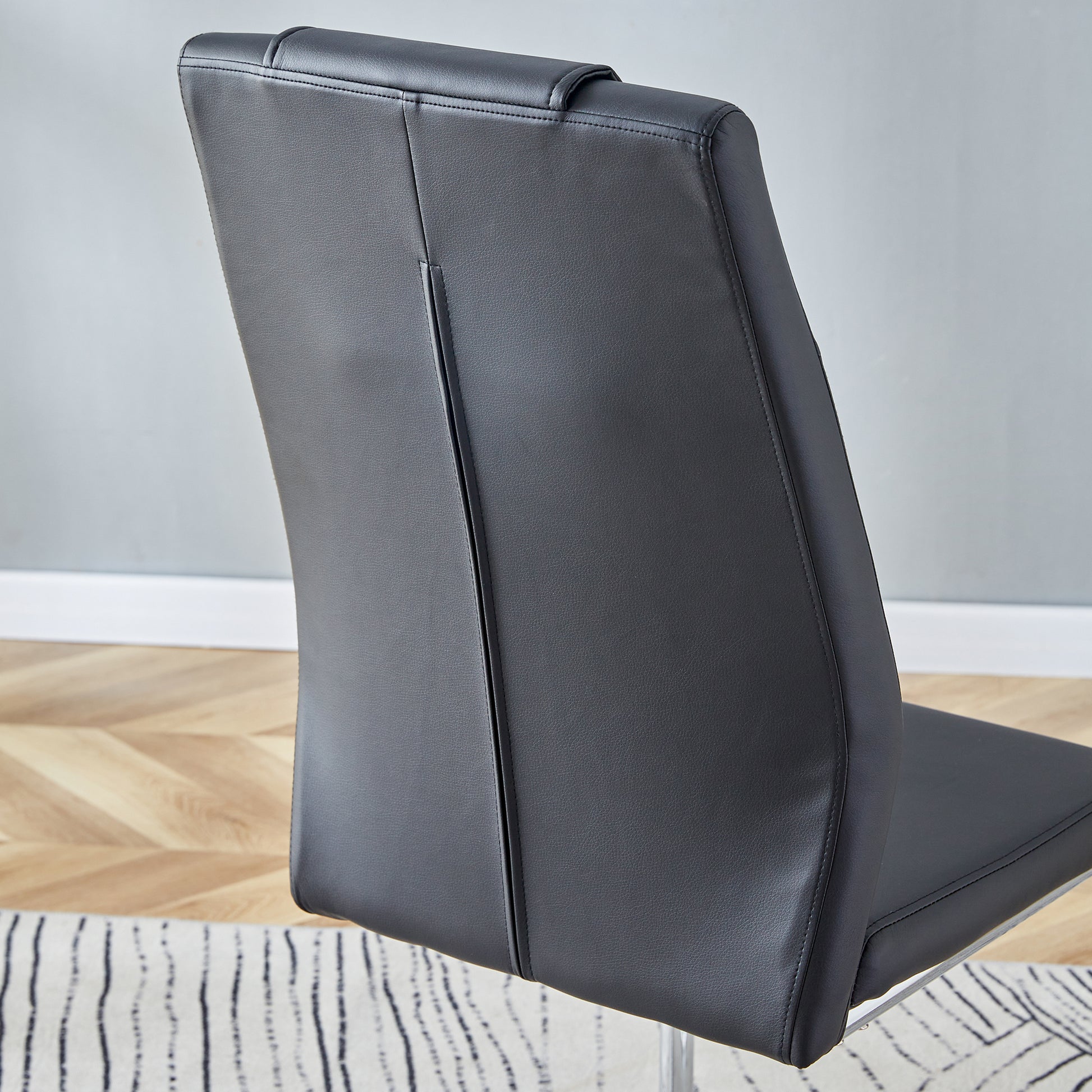 Black faux leather dining chair with stitched detail