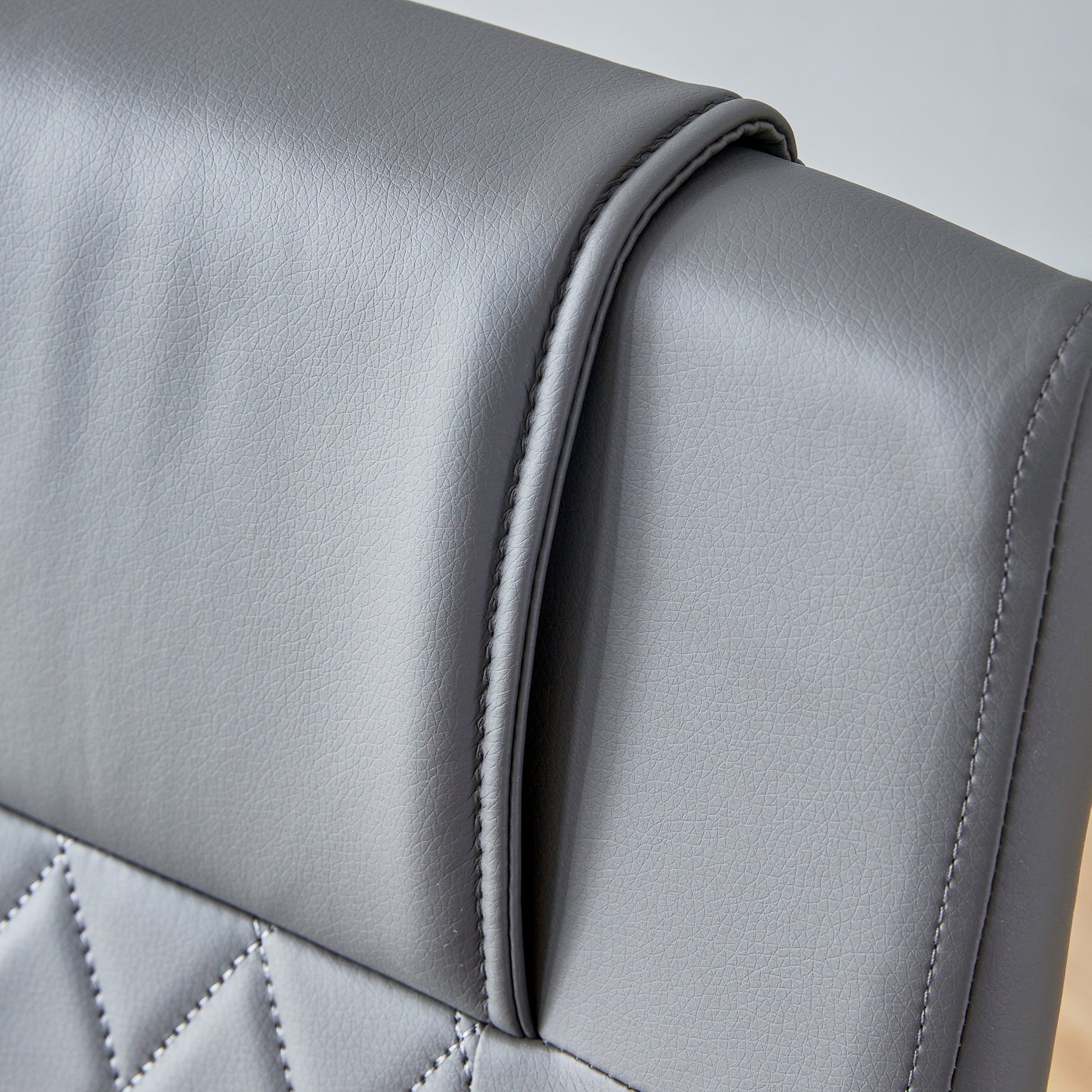 Closeup of grey faux leather headrest with piped seam