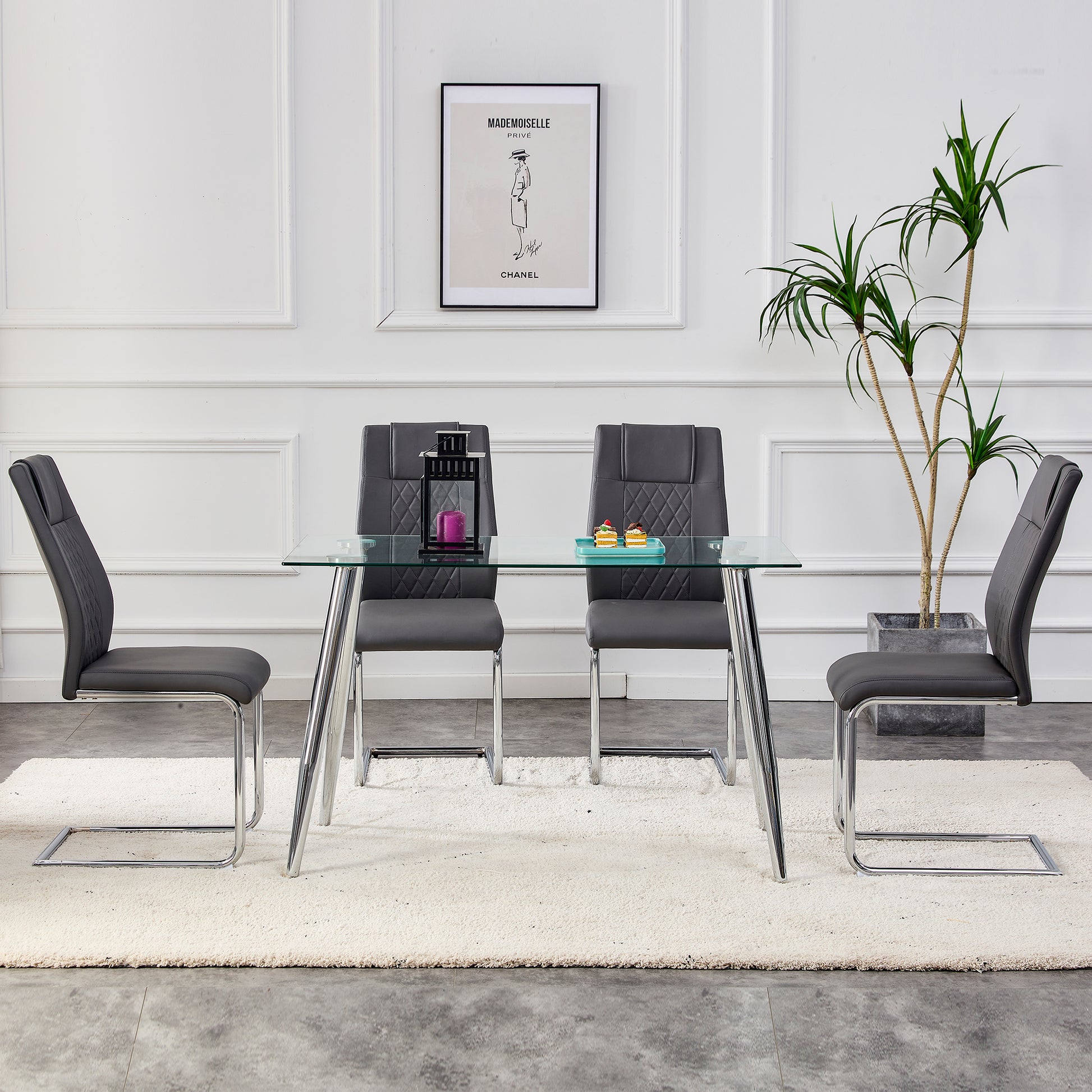 Modern glass dining table with four dark grey upholstered chairs