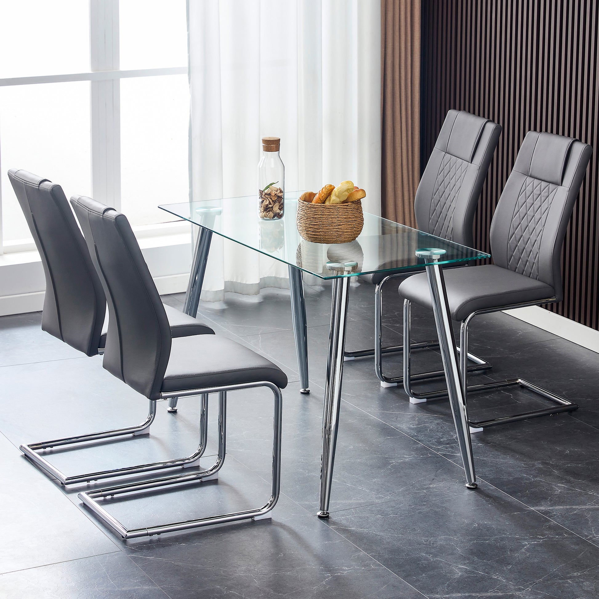 Contemporary glass dining table with four dark gray leather chairs