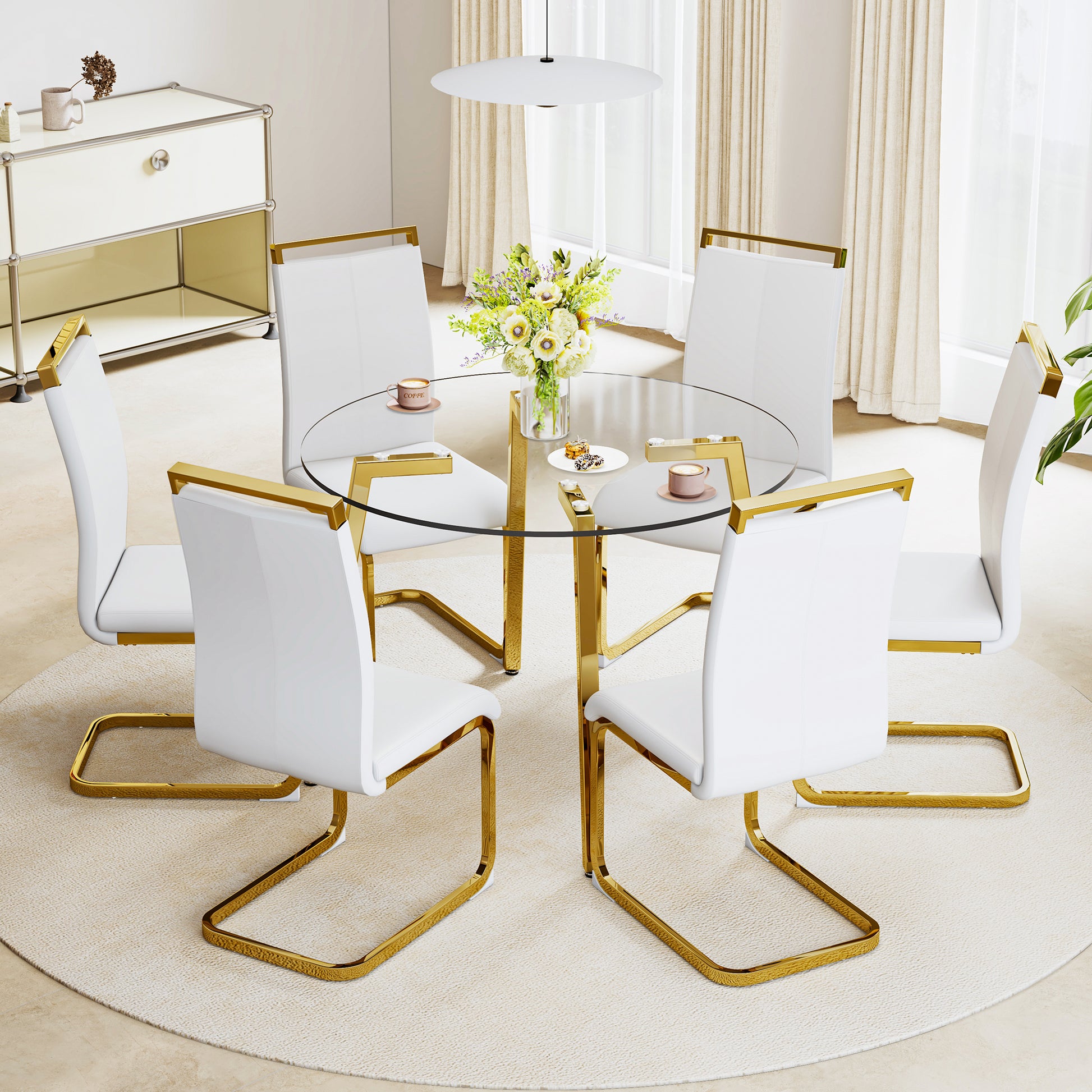 Modern white dining chairs with gold frames around a glasstop dining table