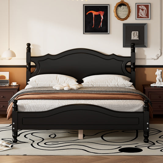 Black wood fourposter bed with white bedding and a patterned rug