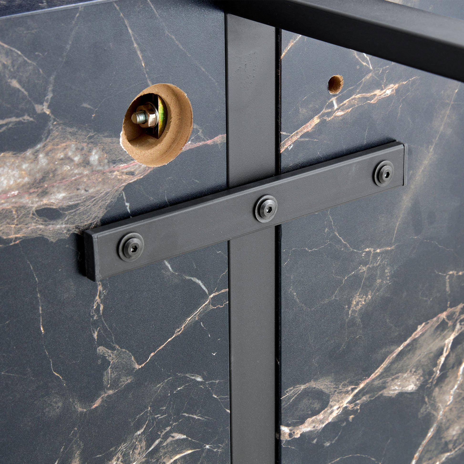 Closeup of black marble effect panel with gold veining and metal frame support