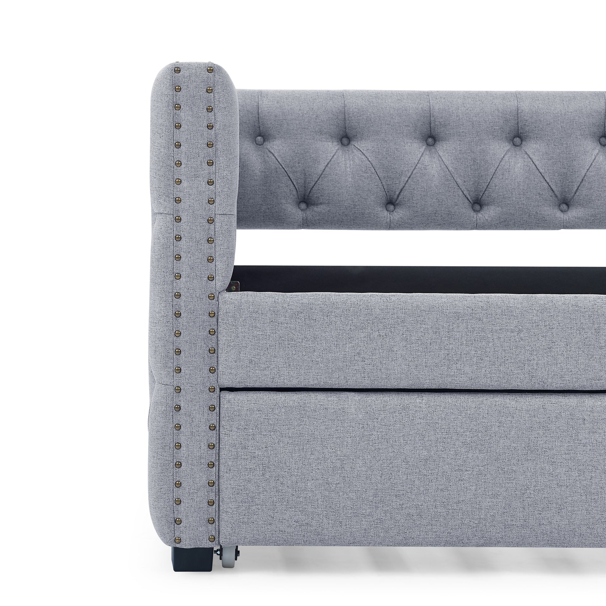 Grey upholstered bed frame with tufted headboard and antique brass nailhead trim