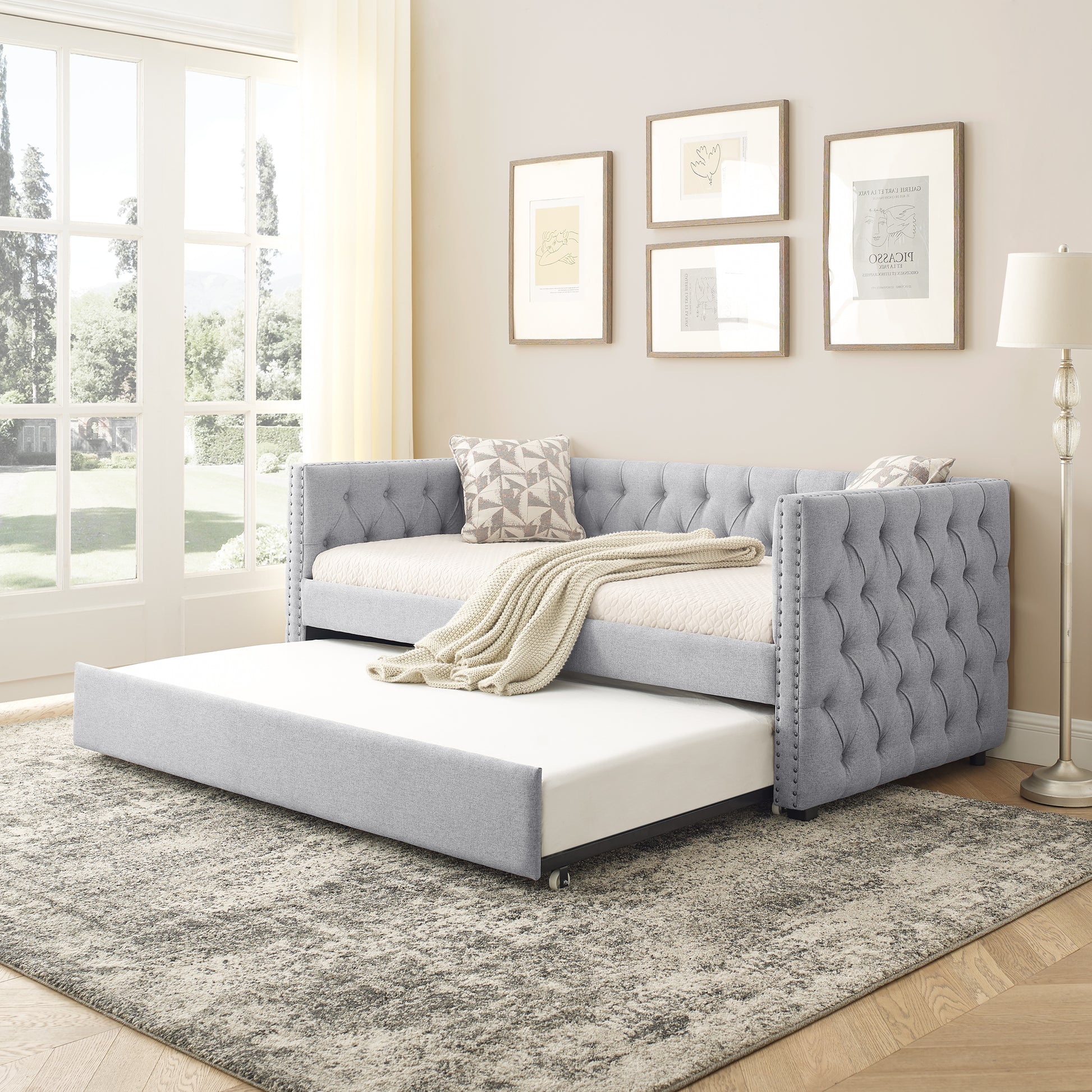 Grey upholstered daybed with tufted back and pullout trundle perfect for guest rooms