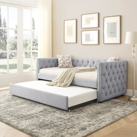 Grey upholstered daybed with tufted back and pullout trundle perfect for guest rooms