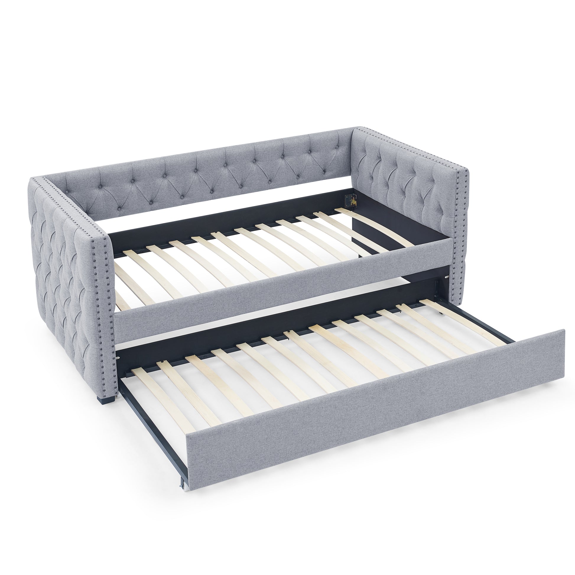 Tufted grey fabric daybed with pullout trundle featuring studded trim for a classic look