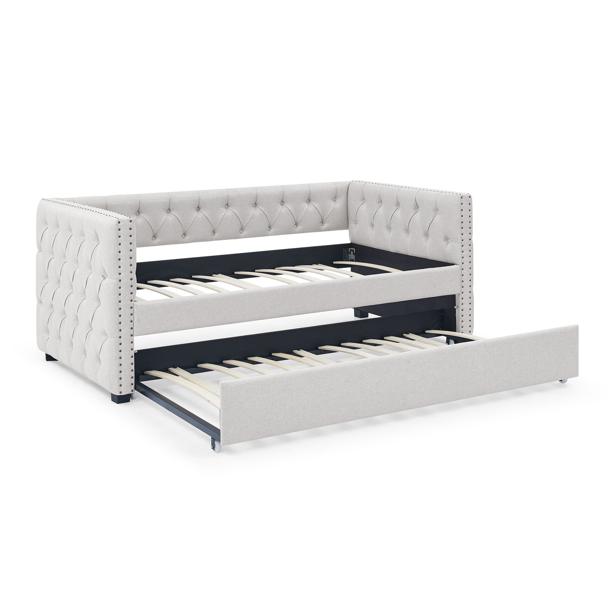 Tufted light gray fabric daybed with pullout trundle and silver nailhead trim