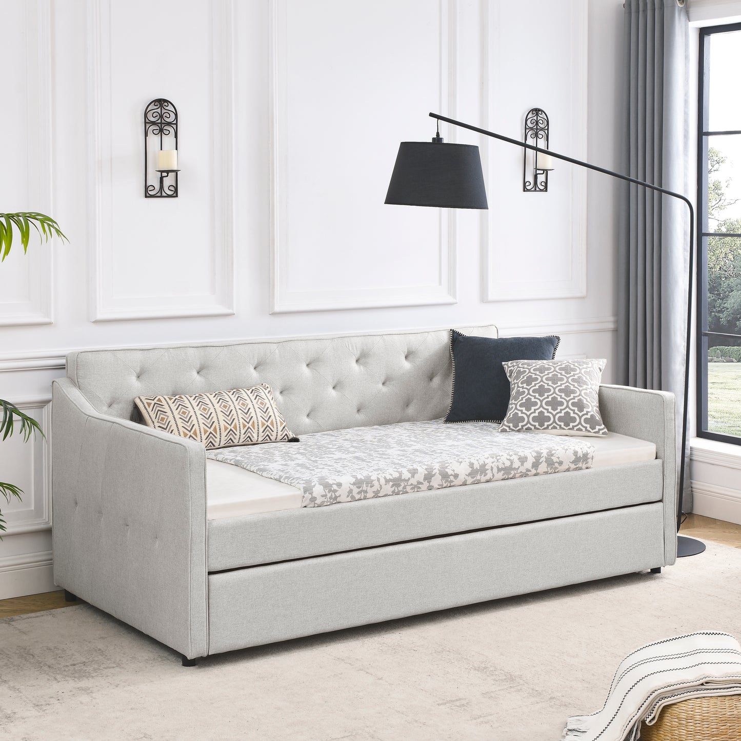 Light gray upholstered daybed with pullout trundle and tufted back perfect for guest rooms