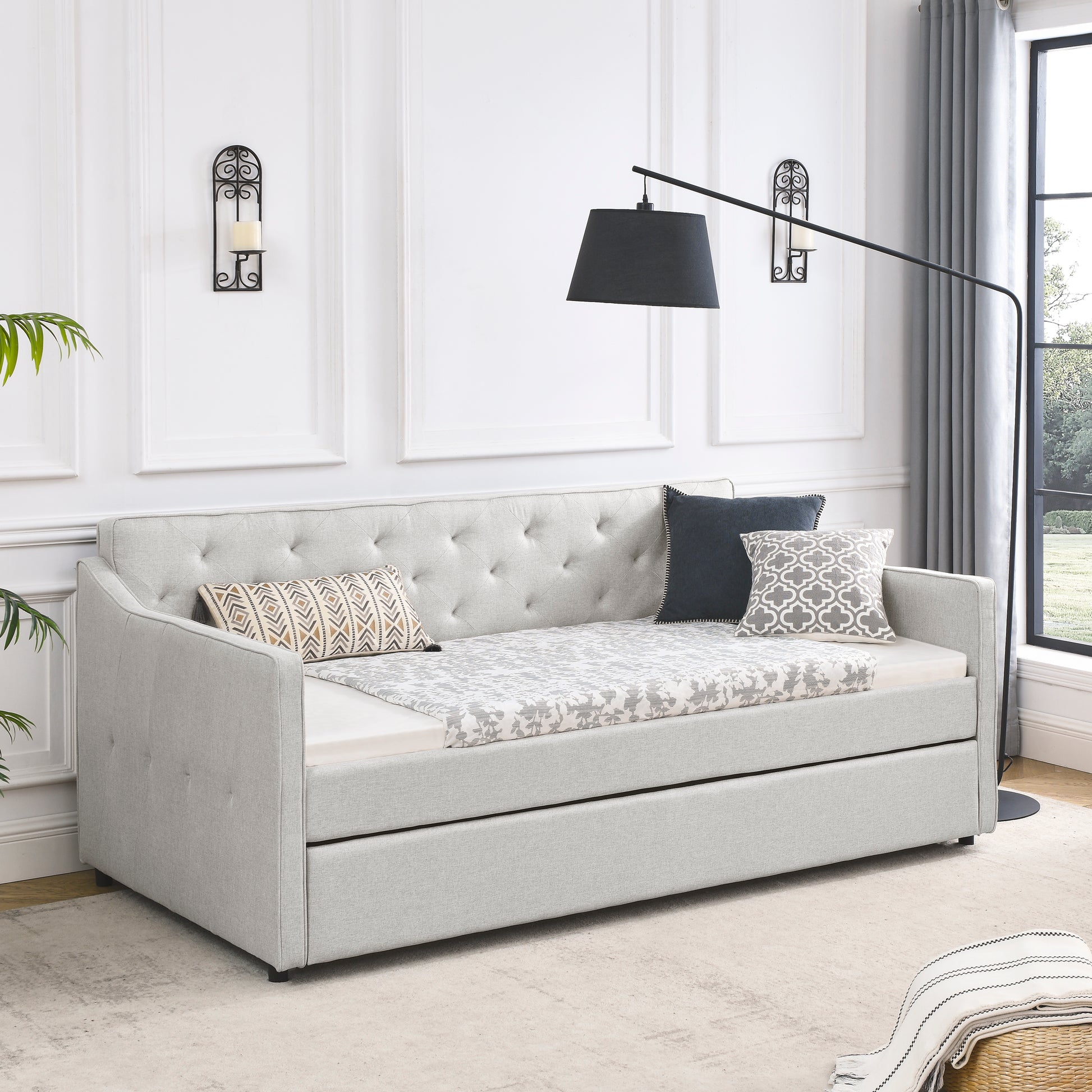 Light gray upholstered daybed with pullout trundle and tufted back perfect for guest rooms
