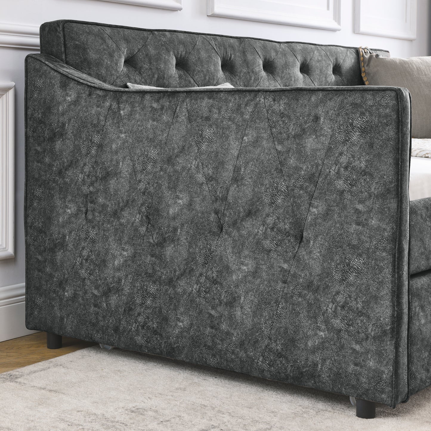 Dark gray tufted daybed with diamond pattern upholstery and textured fabric