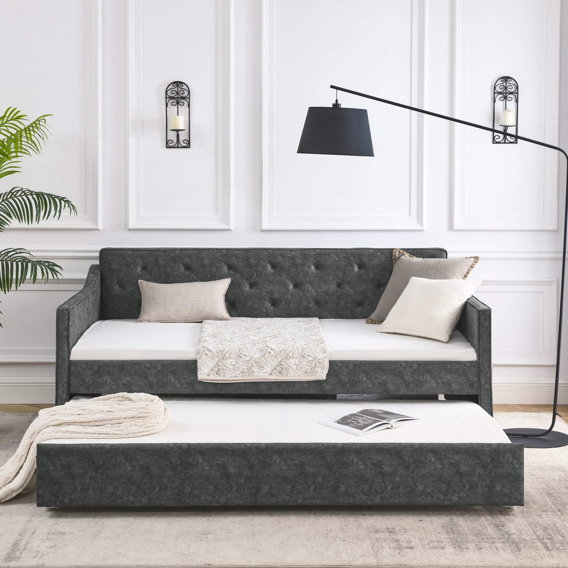 Dark gray upholstered daybed with pullout trundle and tufted back perfect for small spaces