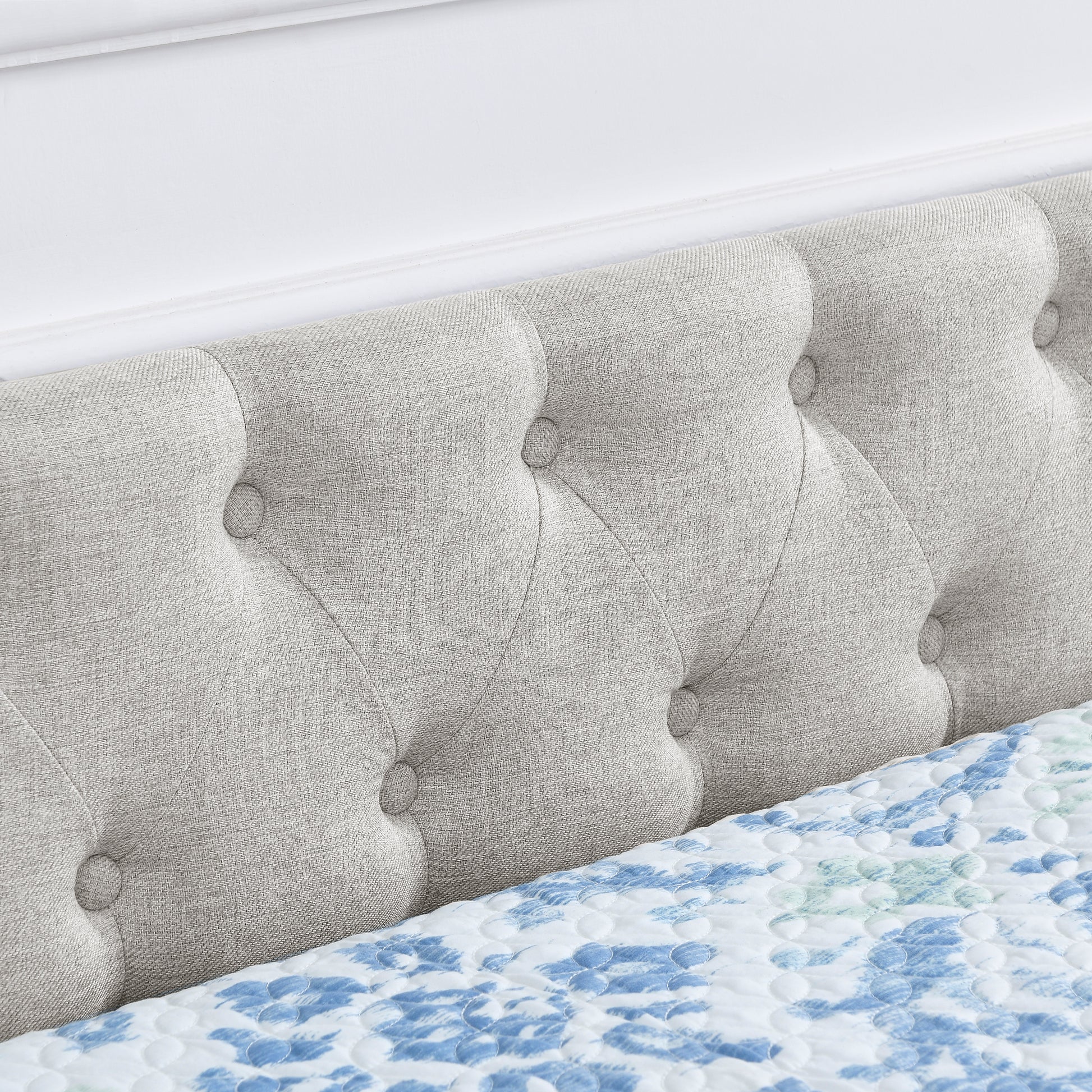 Tufted light gray upholstered headboard with button details part of a modern bed frame set
