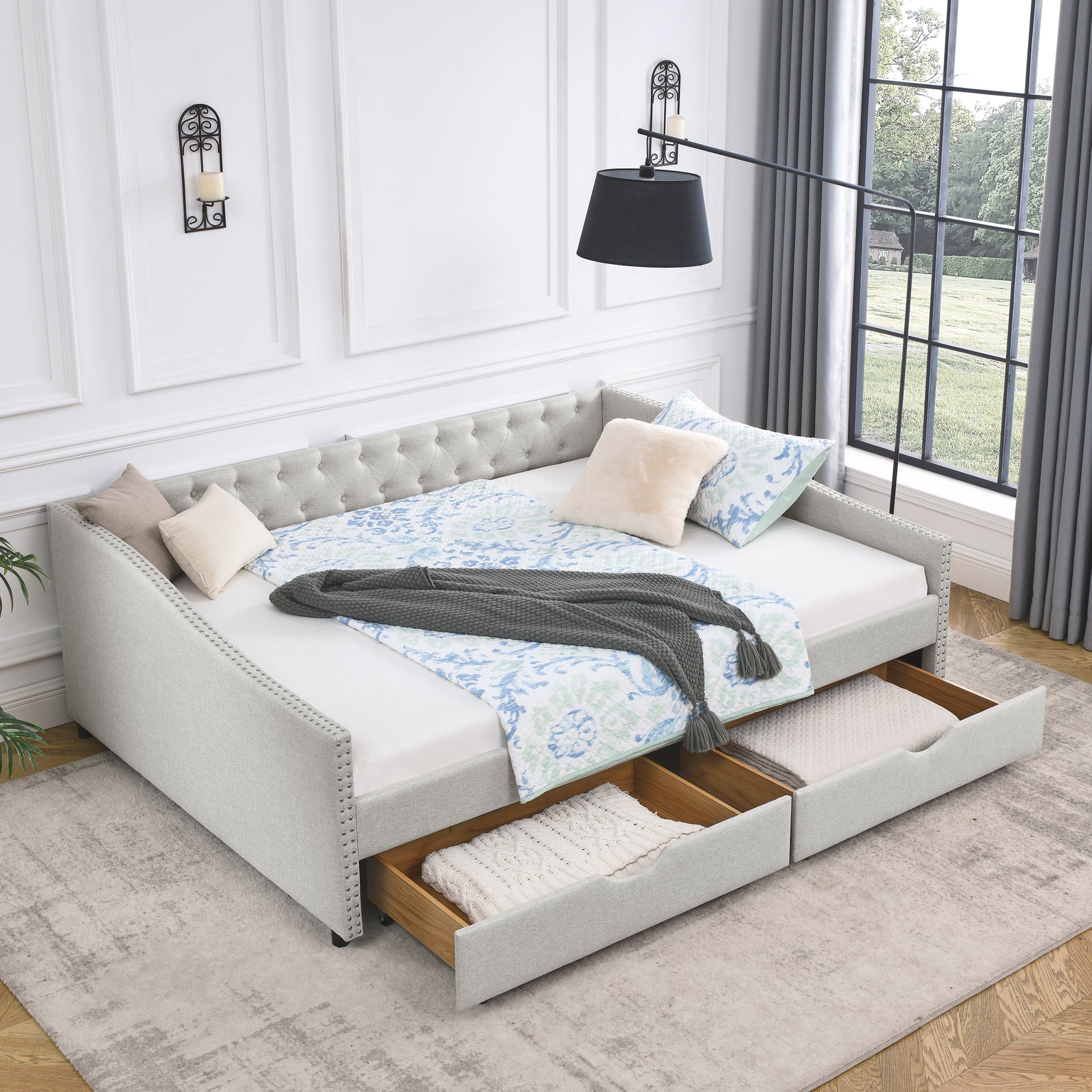Light gray upholstered daybed with nailhead trim and two drawers for storage