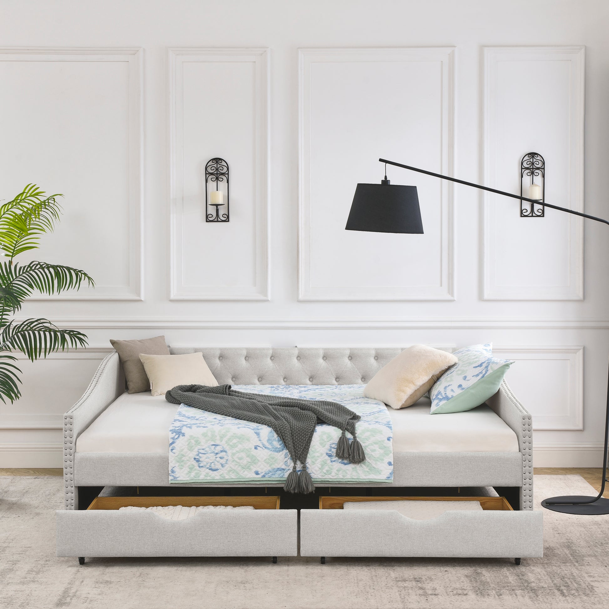 Light gray upholstered daybed with tufted back and silver nailhead trim
