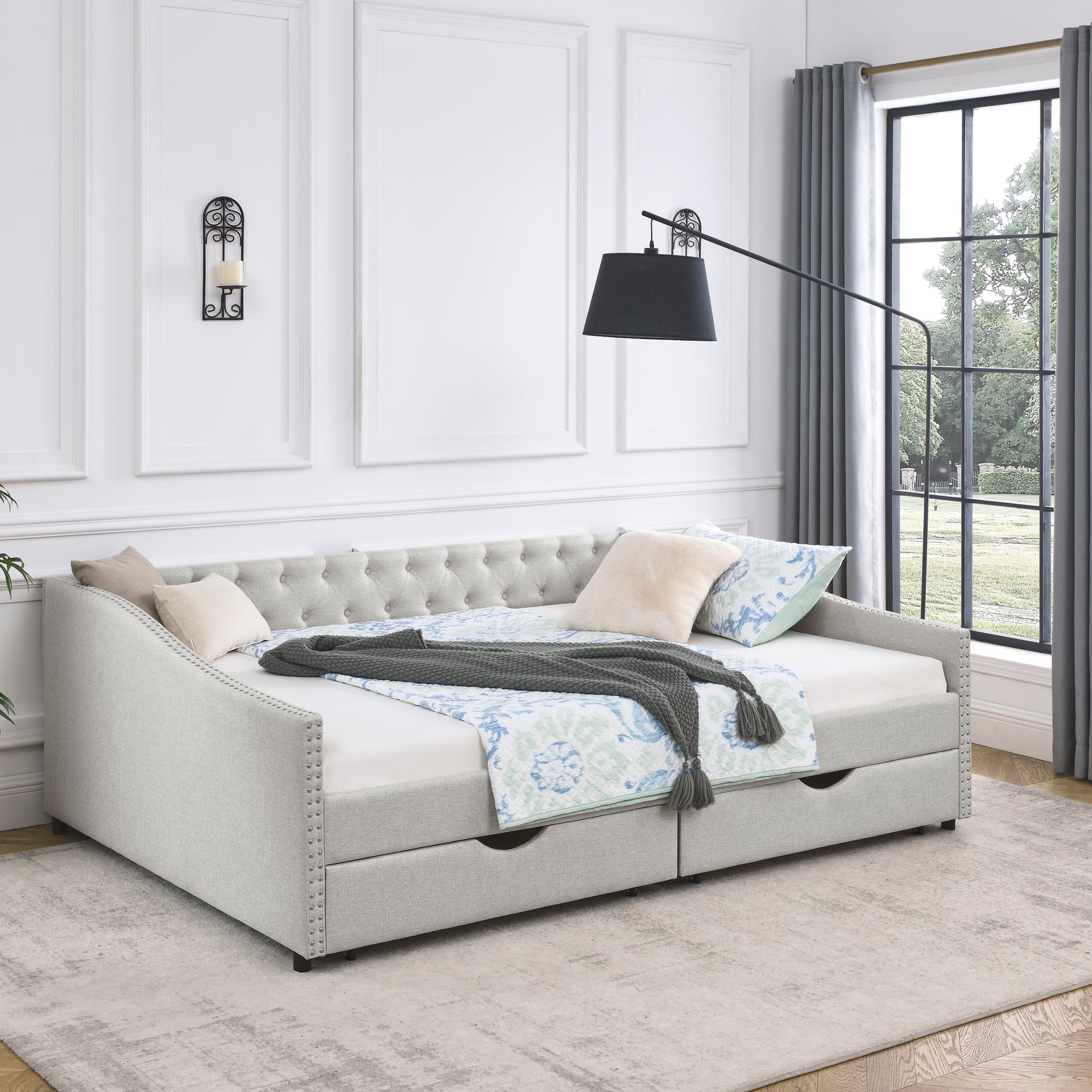 Tufted back light gray fabric daybed with nailhead trim and two storage drawers