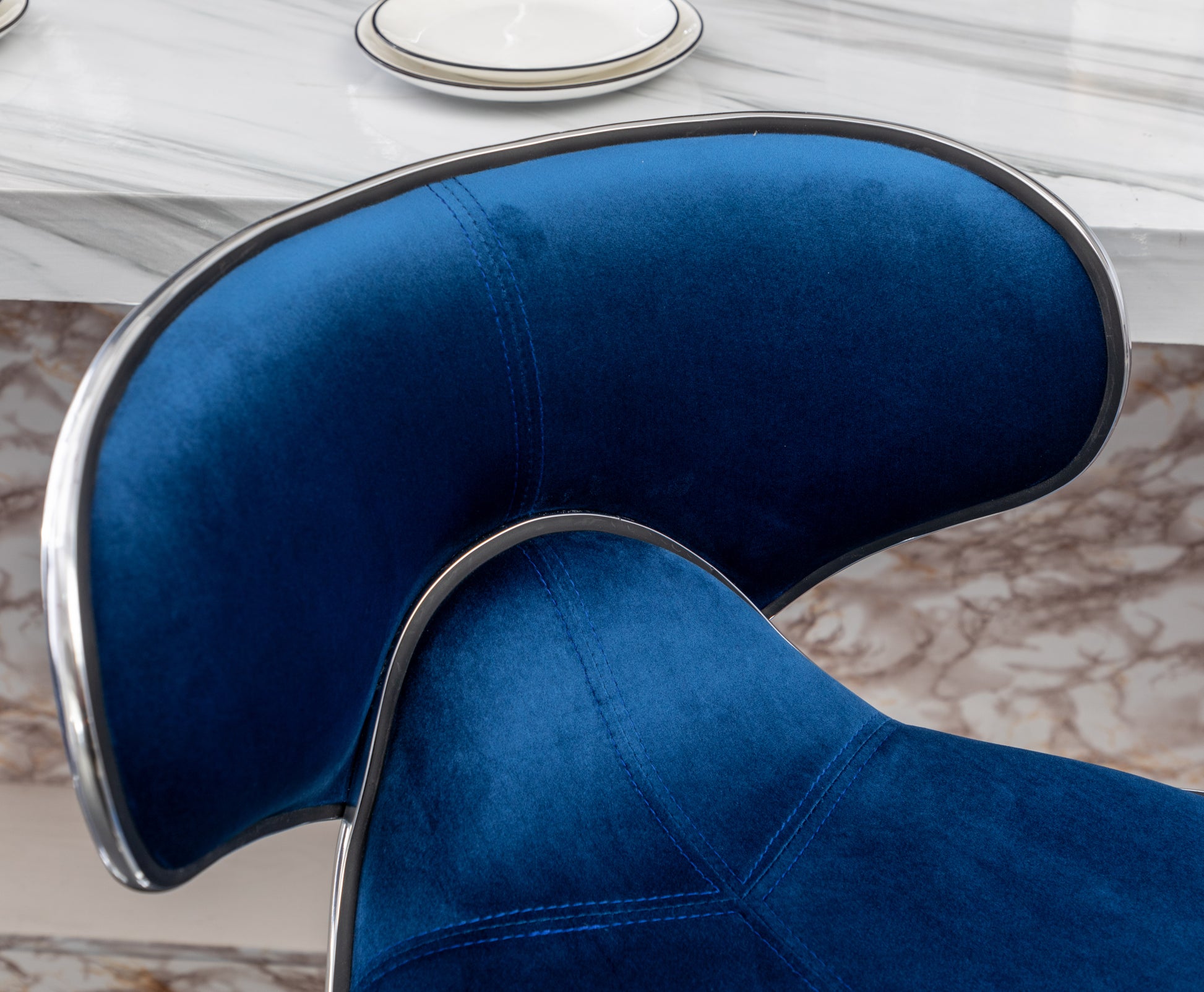 Deep blue velvet bar stool with chrome trim and stitched detailing