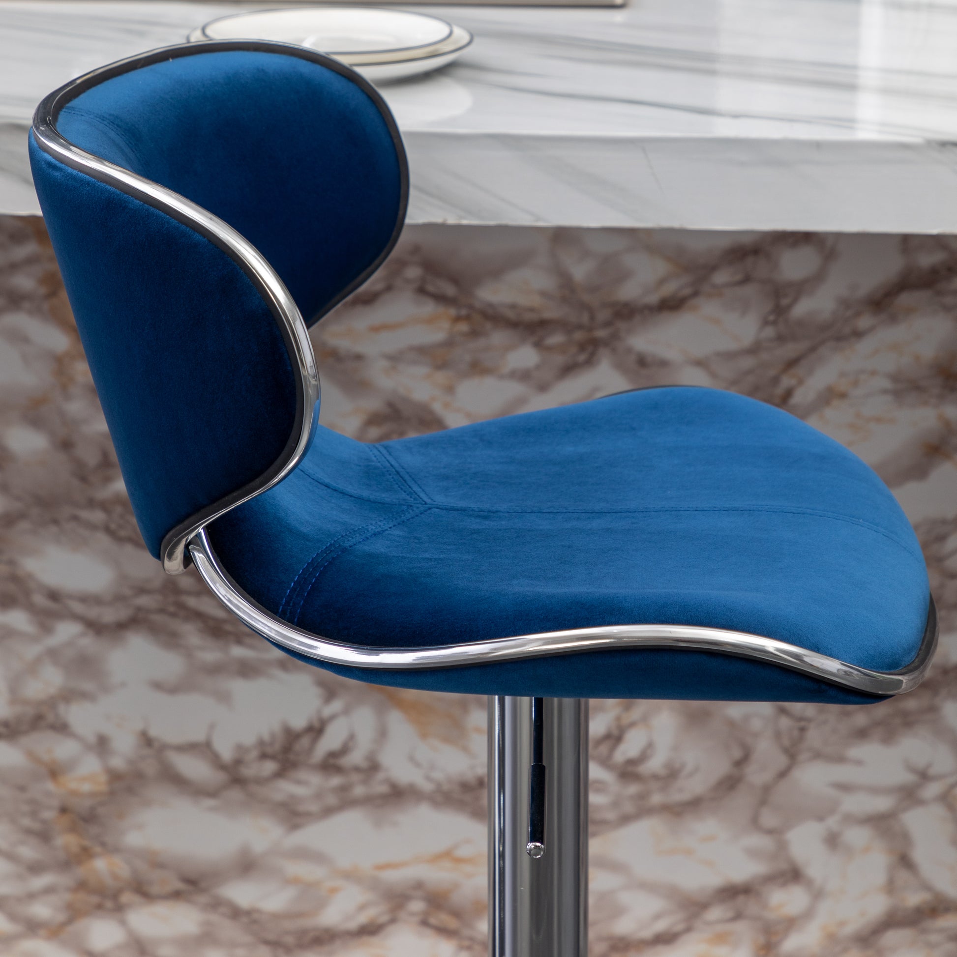 Plush blue velvet bar stool with a sleek chrome trim and adjustable height