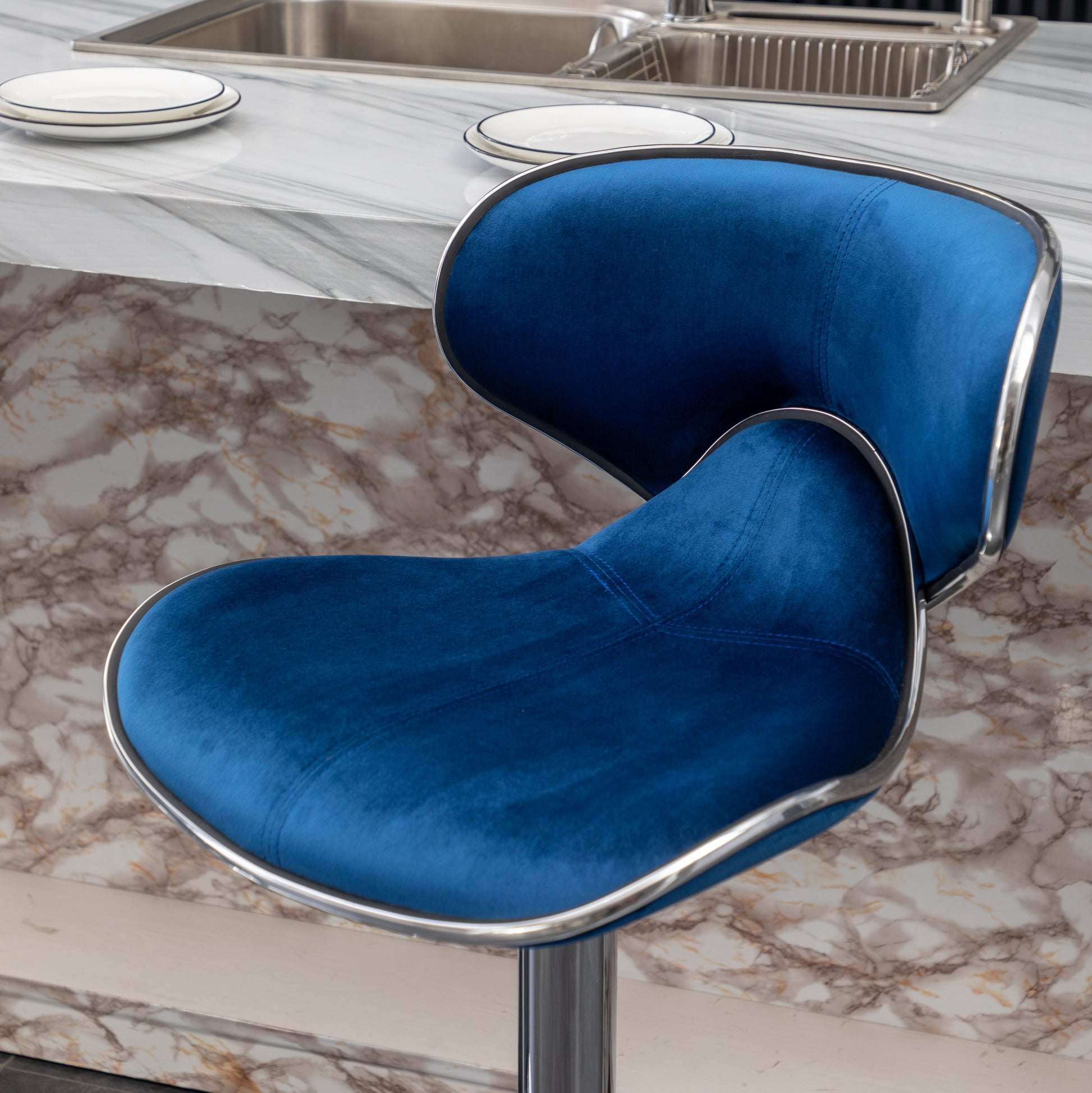 Plush blue velvet bar stool with chrome accents and a sleek design