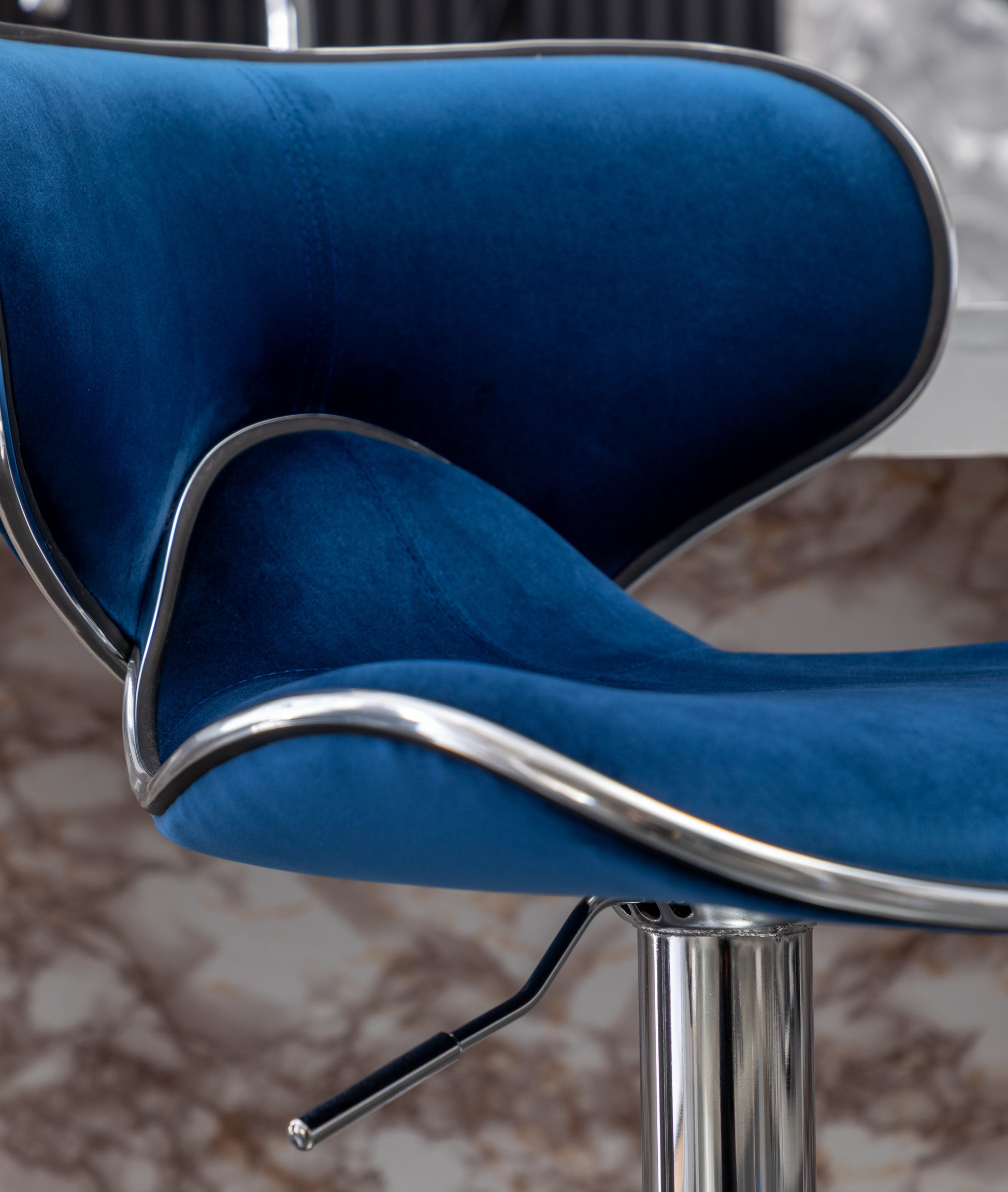 Closeup of plush blue velvet bar stool seat with chrome trim