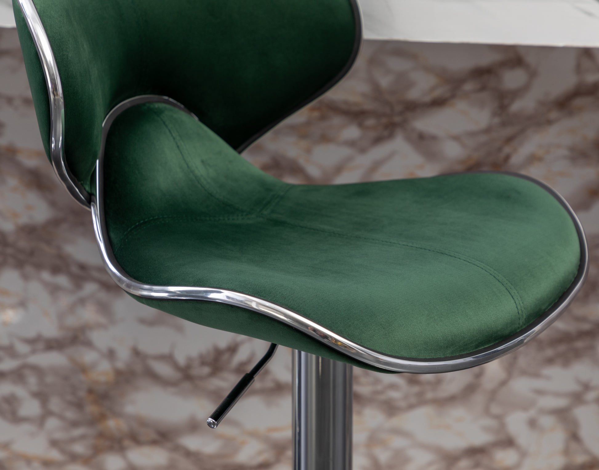 Green velvet bar stool with polished chrome accents and adjustable height lever
