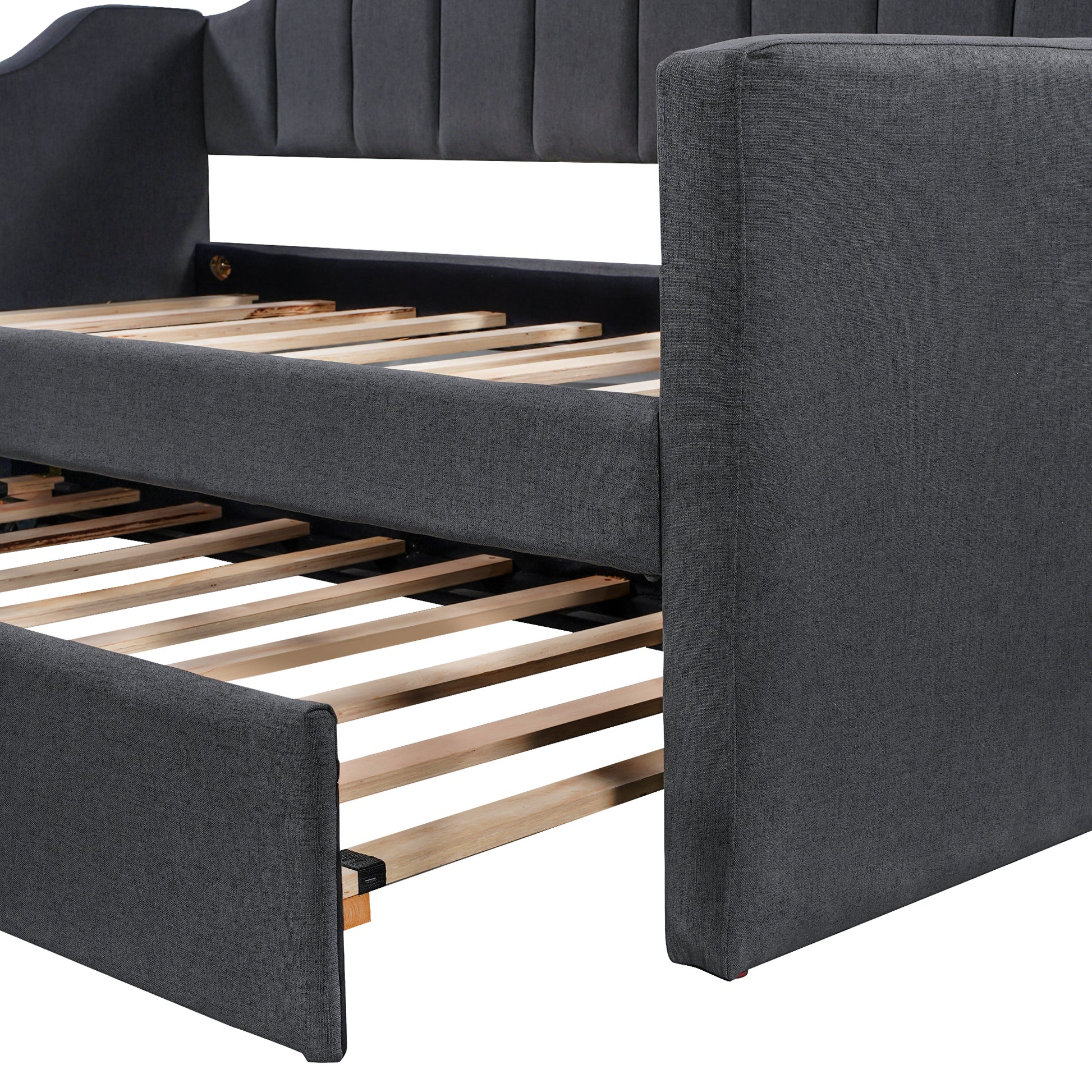 Dark gray upholstered daybed with channel tufted headboard and wooden slats showing