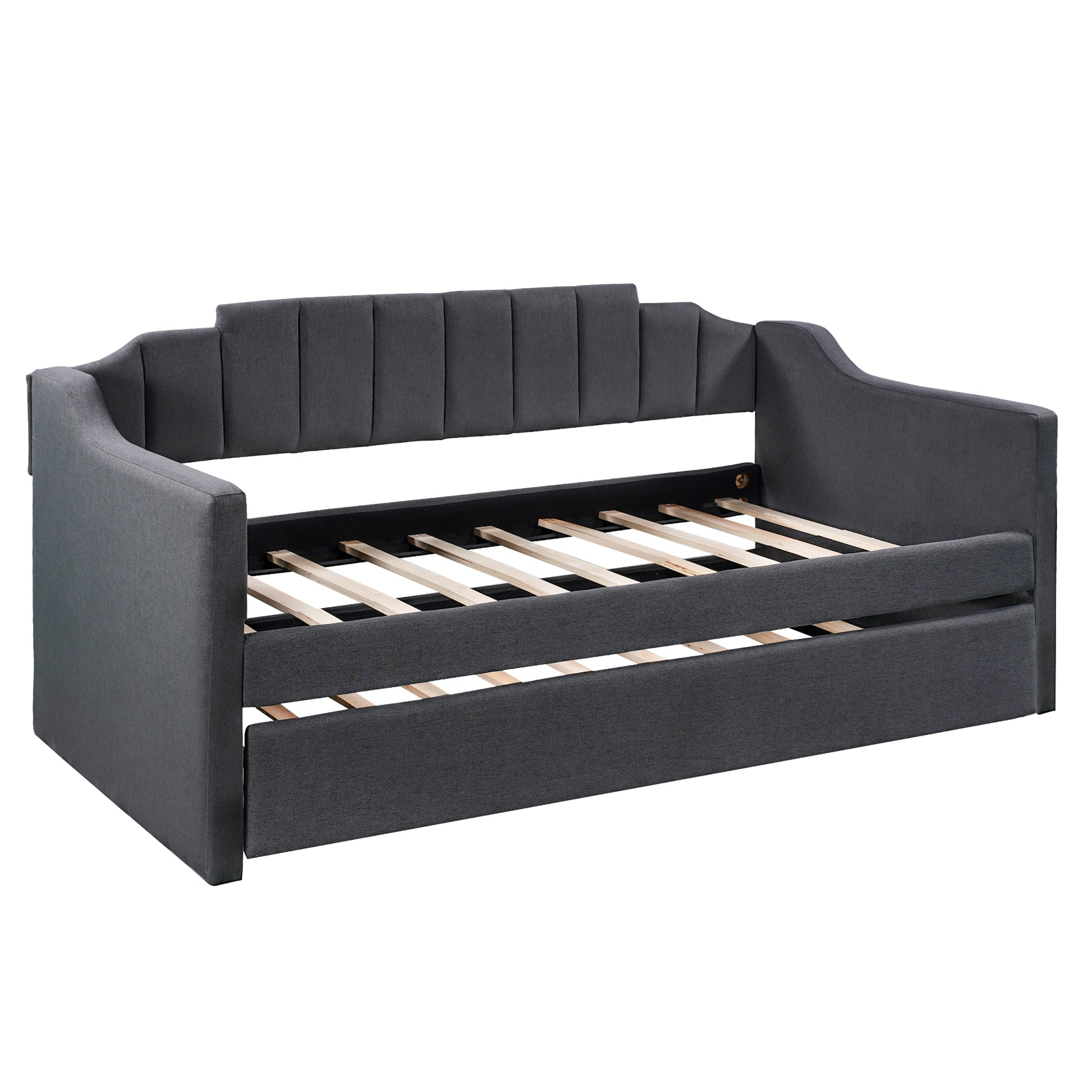 Dark gray upholstered daybed with a pullout trundle and vertical channel tufting on the backrest