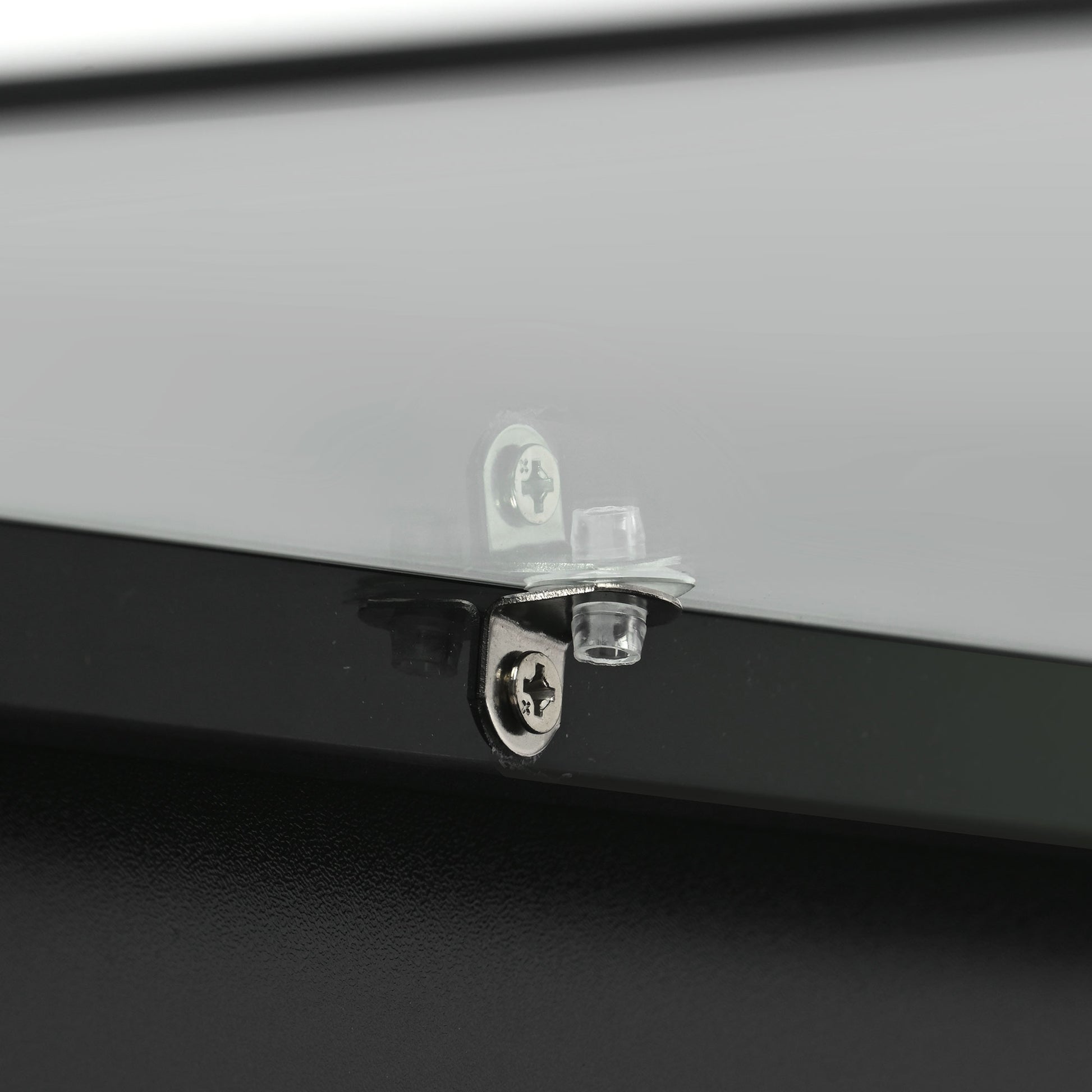 Closeup of glass shelf support with chrome screw and clear plastic bushing